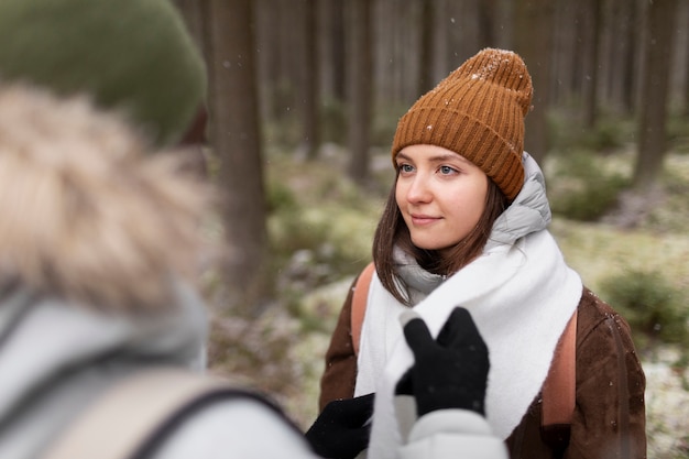 Jong stel op een winterse roadtrip samen wandelen door het bos