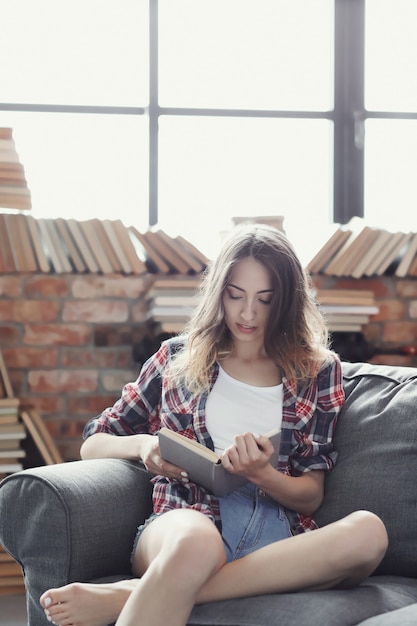 Gratis foto jong tienermeisje dat een boek thuis leest