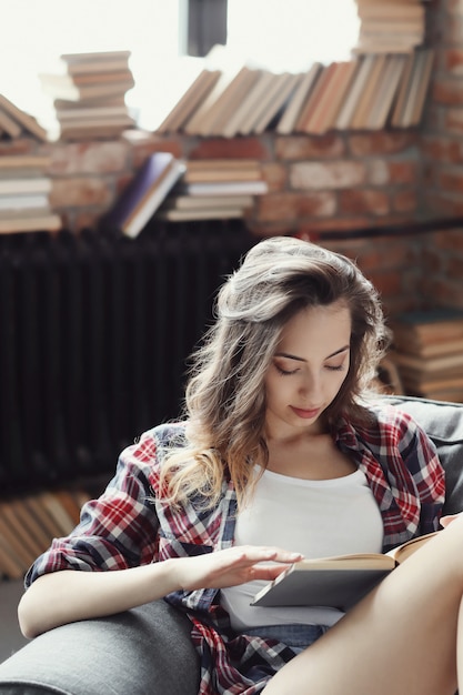 Gratis foto jong tienermeisje dat een boek thuis leest