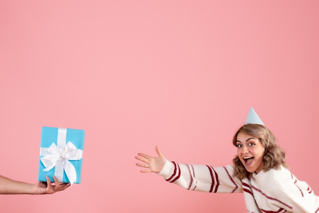 Jong wijfje dat het cadeau van het mannetje op roze accepteert