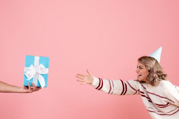 jong wijfje dat het cadeau van het mannetje op roze accepteert