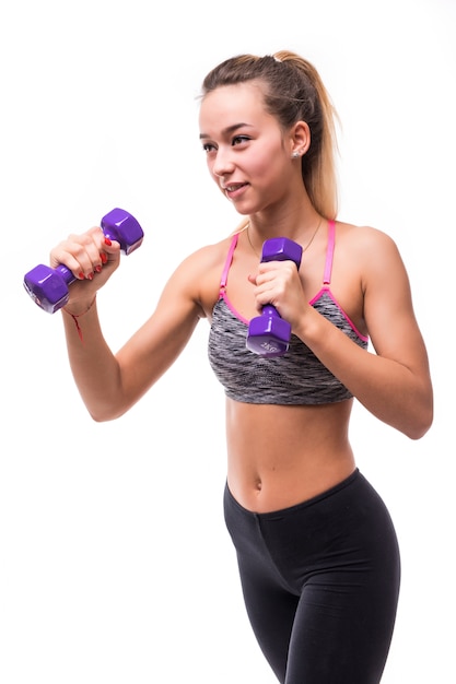 Jonge aantrekkelijke fitness meisje vrouw maken verschillende aerobics kick oefeningen met halters op wit gekleed in sportkleding