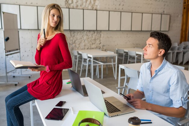 Jonge aantrekkelijke mensen die online samenwerken in open ruimte co-working kantoorruimte