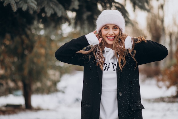 Gratis foto jonge aantrekkelijke vrouw in een winter park in een schattige hoed