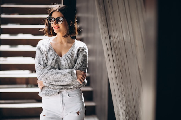 Gratis foto jonge aantrekkelijke vrouw in witte jeans buiten de straat