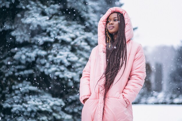 Jonge Afrikaanse Amerikaanse vrouw in de winter buiten in park