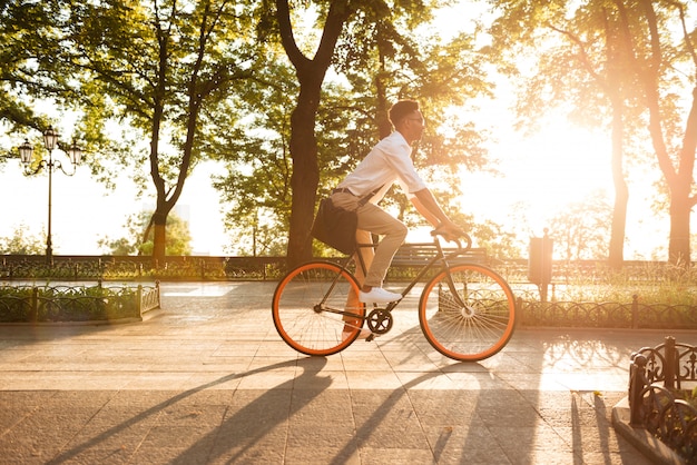 Jonge Afrikaanse man in de vroege ochtend met fiets wandelen