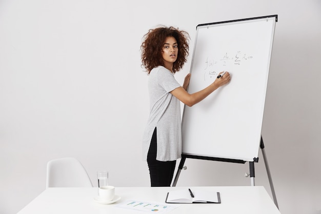 Jonge Afrikaanse vrouw die haar ideeën uitleggen aan een investeerder of een bus zijn bij het bouwen van succesvol bedrijfsproces, startincubatoronderzoek, spoedig miljonair worden, wijzend op het concept.