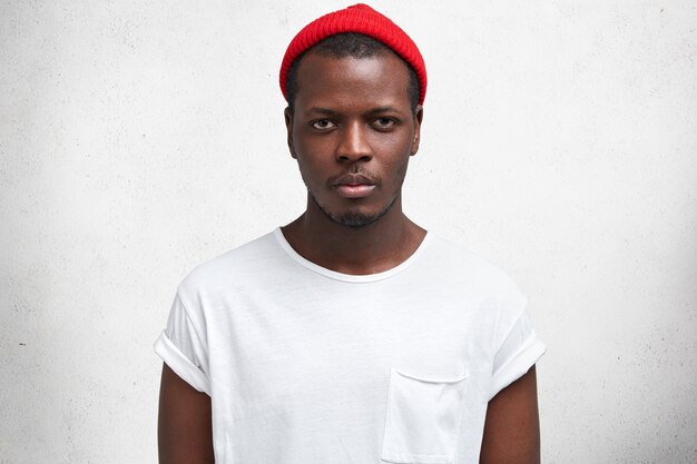 Jonge Afro-Amerikaanse man in wit T-shirt en rode hoed