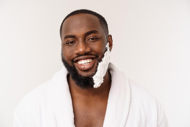 Jonge Afro-Amerikaanse man scheert zich in de badkamer persoonlijke ochtend routine hygiëne bij ochtend concept