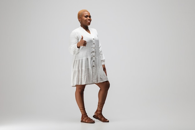 Jonge afro-amerikaanse vrouw in vrijetijdskleding op grijze achtergrond