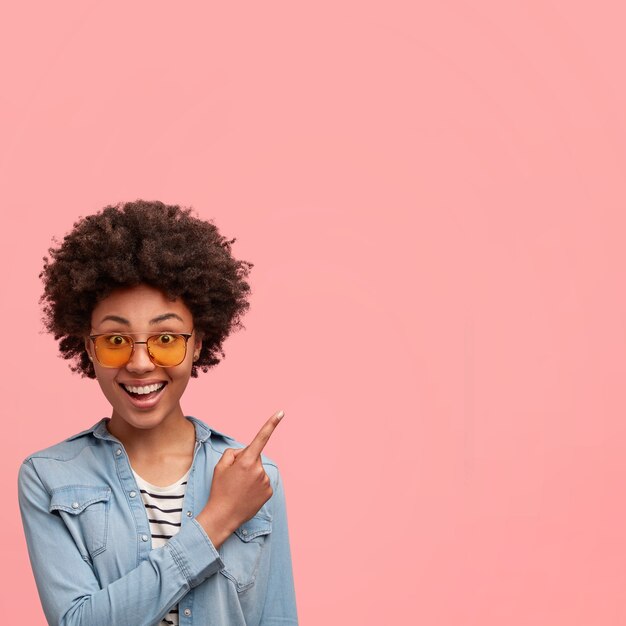 Jonge Afro-Amerikaanse vrouw met gekleurde zonnebril