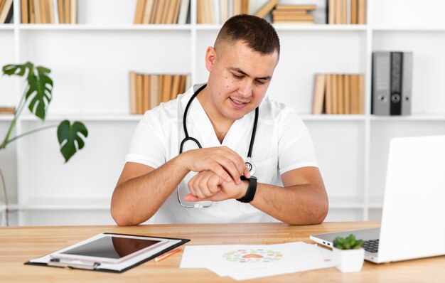 Jonge arts die zijn horloge bekijkt