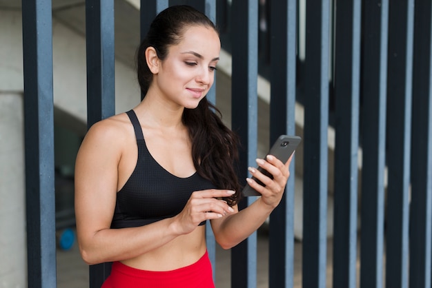 Jonge atletenvrouw met een smartphone