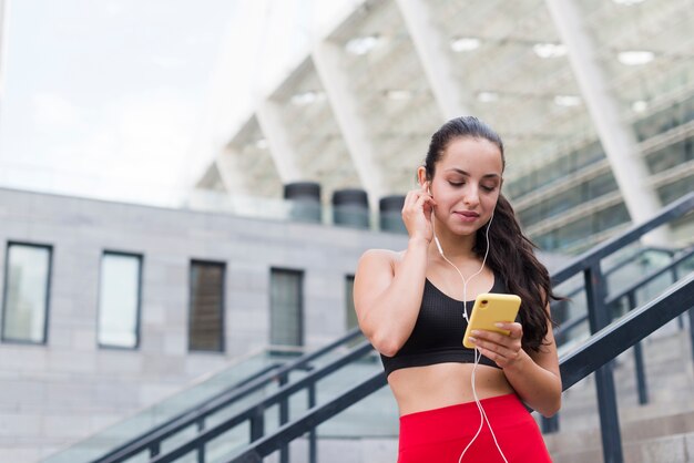 Jonge atletenvrouw met een smartphone