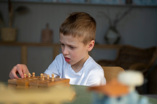 Jonge autistische jongen die thuis met speelgoed speelt