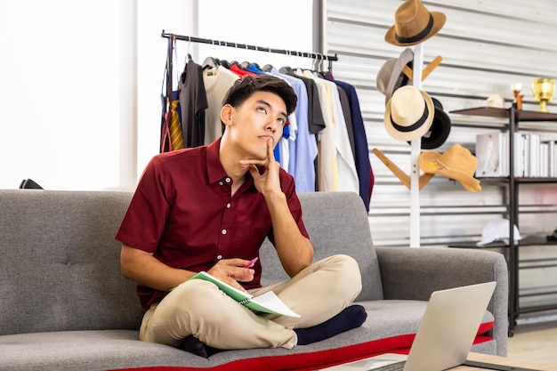 Jonge Aziatische mannelijke online handelaar freelance blogger werkt thuis met laptop Social media Influencer en online winkelconcept