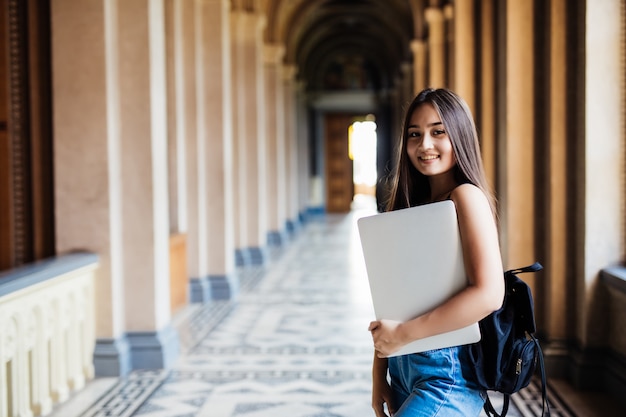 Jonge Aziatische student op universitaire campus met laptop