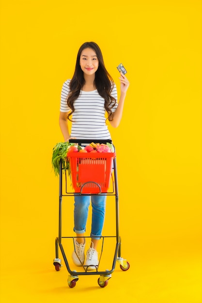 jonge Aziatische vrouw boodschappen kar van supermarkt