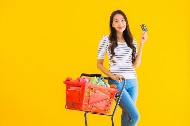 jonge Aziatische vrouw boodschappen kar van supermarkt