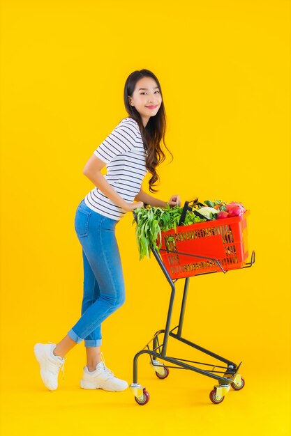 jonge Aziatische vrouw boodschappen kruidenier van supermarkt en kar