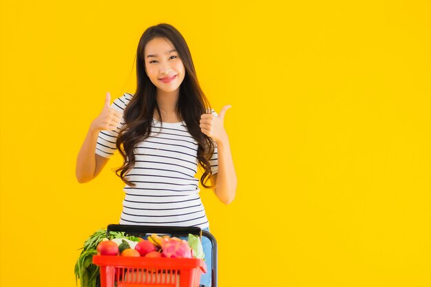 jonge Aziatische vrouw boodschappen kruidenier van supermarkt en kar