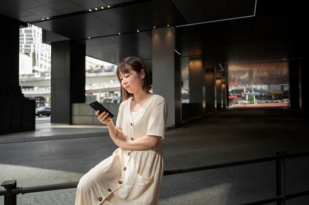 Jonge Aziatische vrouw die haar telefoon controleert