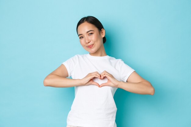 Jonge Aziatische vrouw die het toevallige T-shirt stellen draagt