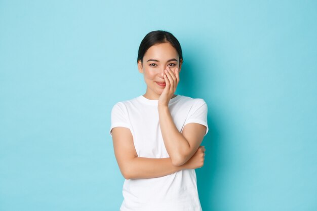 Jonge Aziatische vrouw die het toevallige T-shirt stellen draagt