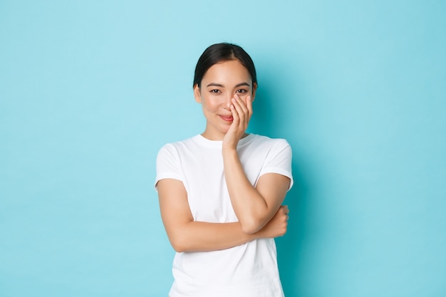 Jonge Aziatische vrouw die het toevallige T-shirt stellen draagt