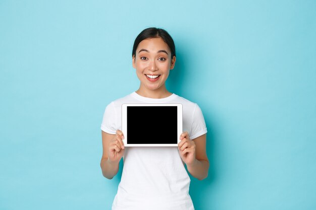 Jonge Aziatische vrouw die het toevallige T-shirt stellen draagt