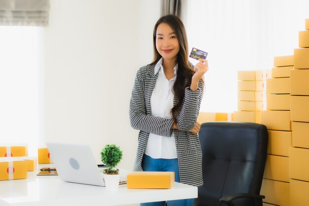 jonge Aziatische vrouw met creditcard en kartonnen doos