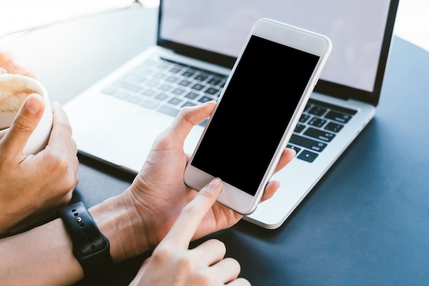 Jonge Aziatische vrouw met smartphone mock up leeg zwart scherm in café