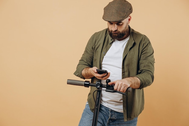 Jonge, bebaarde man die op een elektrische scooter rijdt en telefoon gebruikt