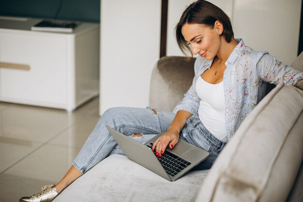 Jonge bedrijfsvrouw die aan een computer thuis werkt