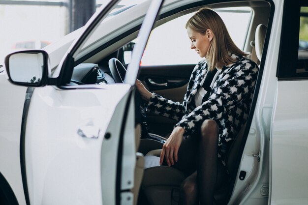 Jonge bedrijfsvrouw die een auto kiest