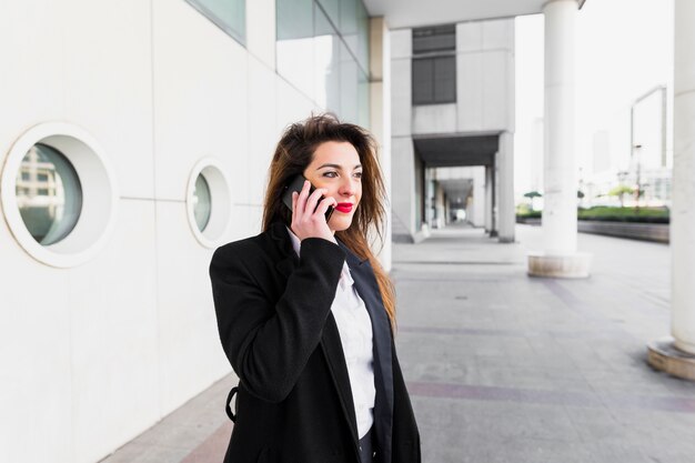 Jonge bedrijfsvrouw die telefonisch spreekt