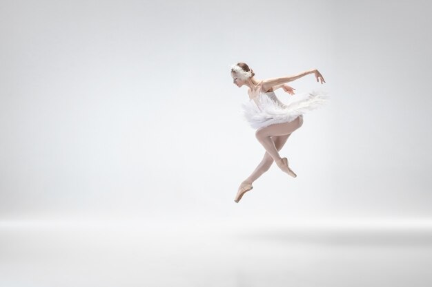 Jonge bevallige ballerina op witte studioachtergrond