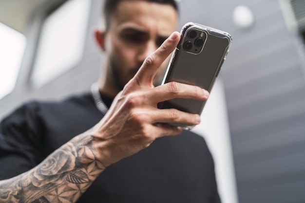 Jonge blanke man uit spanje die de telefoon aan het controleren is met een bezorgd gezicht