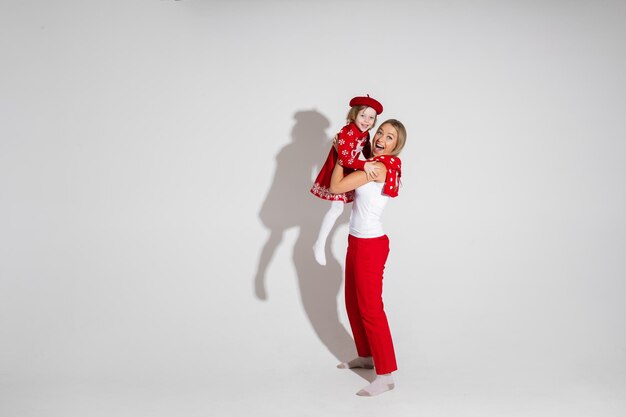 Jonge blanke moeder houdt haar dochter vast, foto geïsoleerd op een witte achtergrond