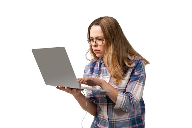 Jonge blanke vrouw met behulp van laptop, apparaten, gadgets geïsoleerd op een witte studio achtergrond. Copyspace