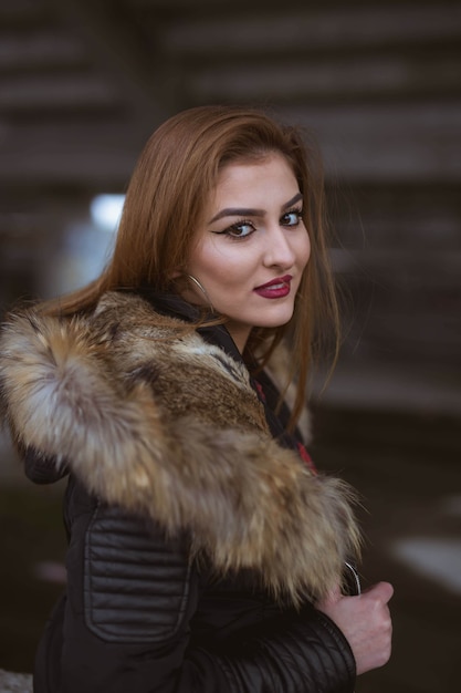 Gratis foto jonge blanke vrouw met bruin haar die een zwarte jas draagt