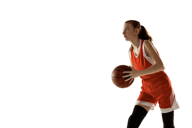 Jonge blanke vrouwelijke basketbalspeler in actie, beweging in run geïsoleerd op een witte achtergrond. redhair sportief meisje. concept van sport, beweging, energie en dynamische, gezonde levensstijl. opleiding.