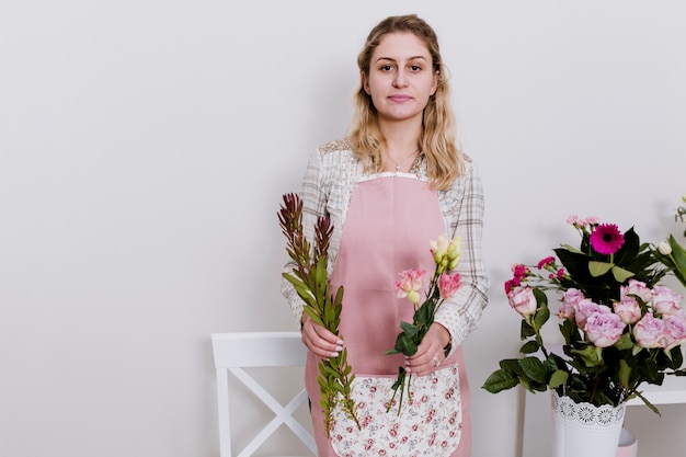 Gratis foto jonge bloemist met bloemen