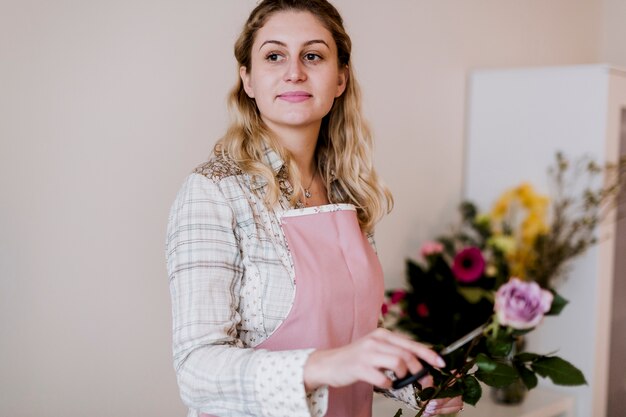 Jonge bloemist vrouw met roos