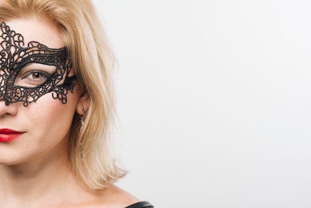 Jonge blonde dame in masker