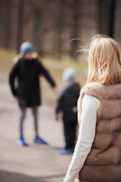 Gratis foto jonge blonde moeder kijkt naar haar kinderen