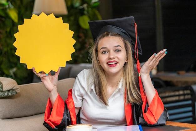 Jonge blonde student houdt ideeënbord vast en kijkt naar de camera