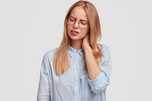 Jonge blonde vrouw, gekleed in blauw shirt