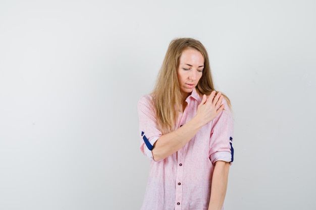 Jonge blonde vrouw in een casual roze shirt